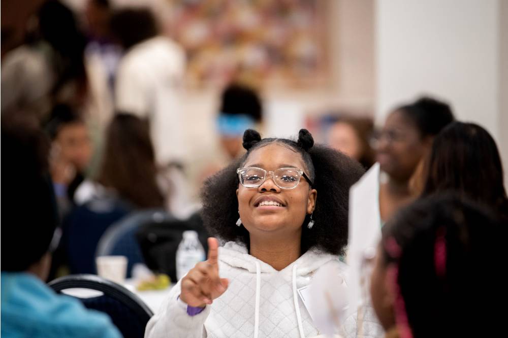 Girls of Color Summit previous event and a kid smiling for a photo